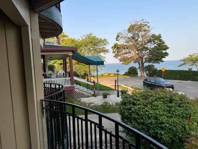 balcony with a water view and covered porch