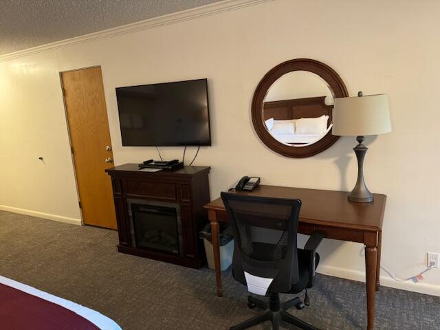 carpeted office with a textured ceiling and ornamental molding