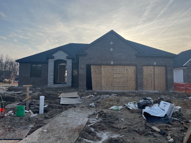 view of front of property featuring an attached garage and brick siding