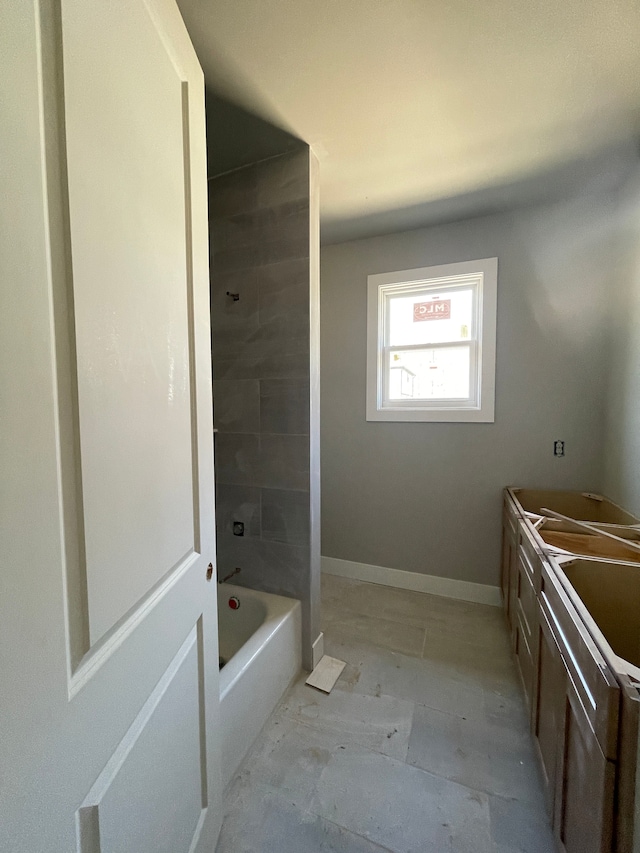 full bathroom featuring double vanity and baseboards