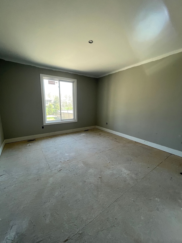 spare room with baseboards