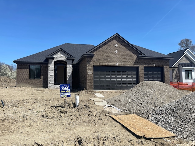view of front of house featuring an attached garage, roof with shingles, and brick siding