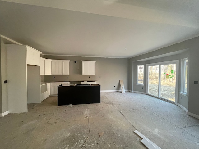 kitchen with baseboards, a center island, and white cabinetry