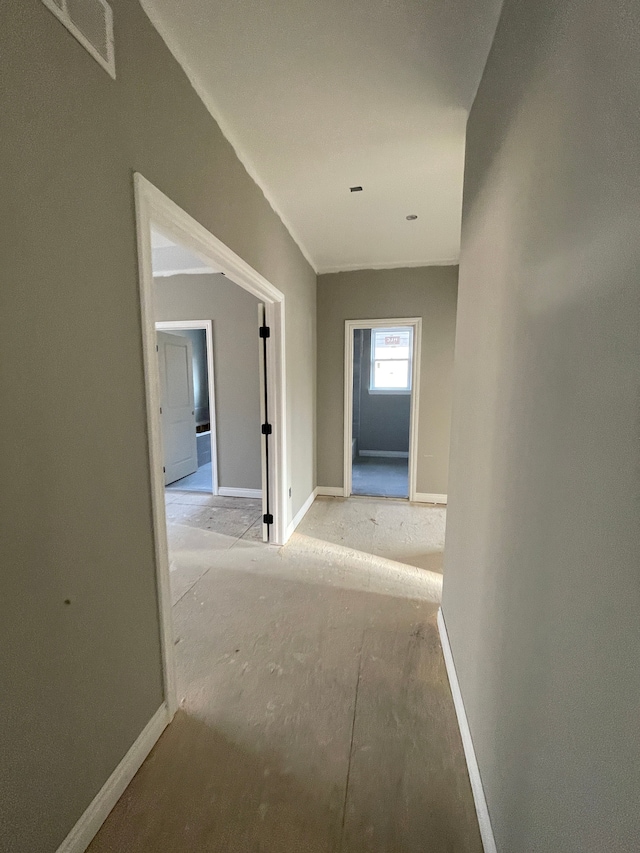 hall featuring visible vents and baseboards