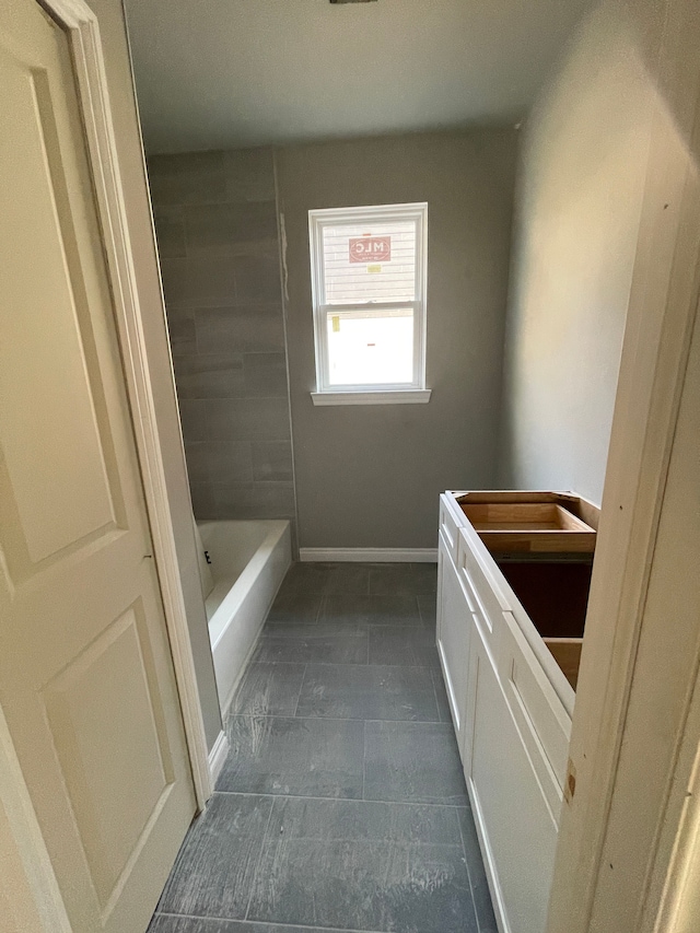 full bathroom with a shower, baseboards, and a bathing tub