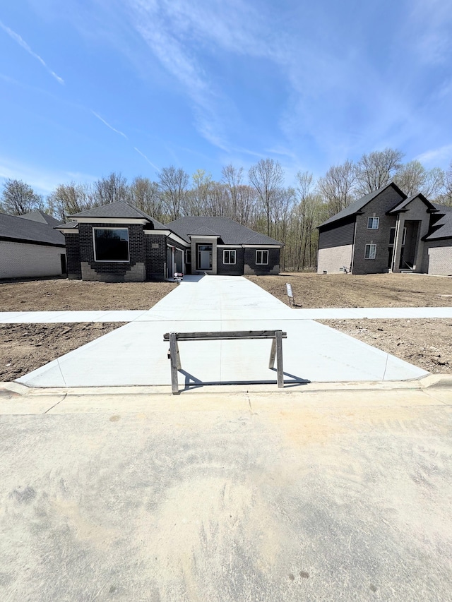 view of front of house featuring concrete driveway and brick siding