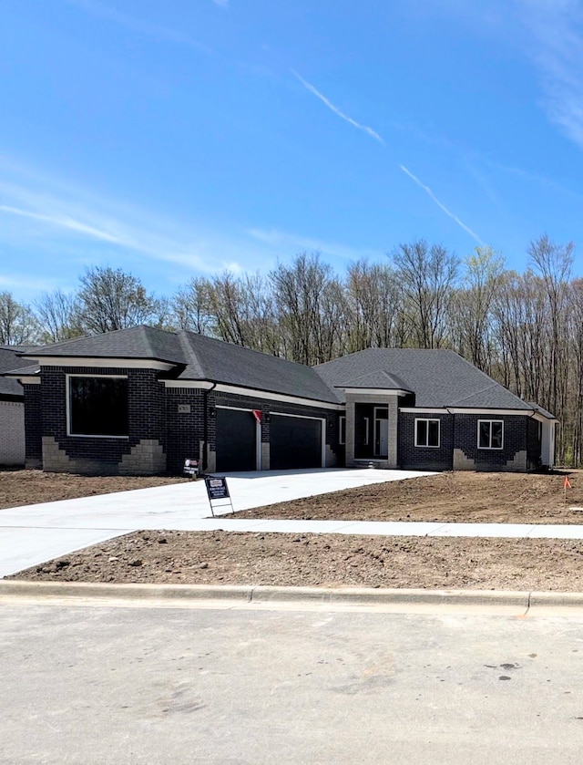 view of front of property with an attached garage, brick siding, and concrete driveway