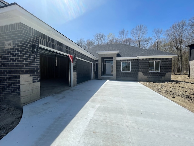 single story home with an attached garage, driveway, and brick siding