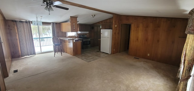 kitchen with vaulted ceiling with beams, kitchen peninsula, white fridge, a breakfast bar area, and stainless steel range with gas stovetop