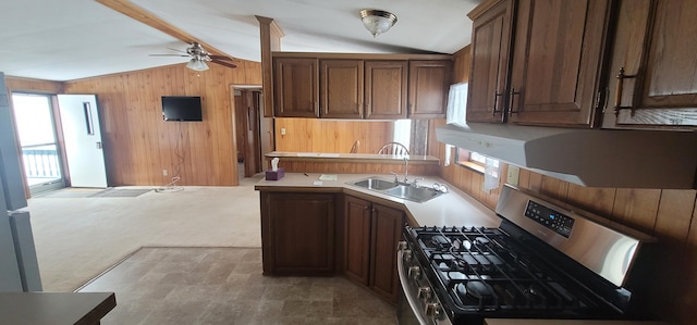 kitchen featuring vaulted ceiling with beams, stainless steel gas stove, and a wealth of natural light