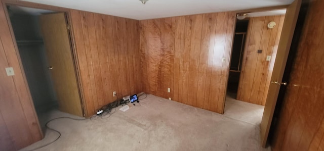 interior space featuring light colored carpet and wooden walls