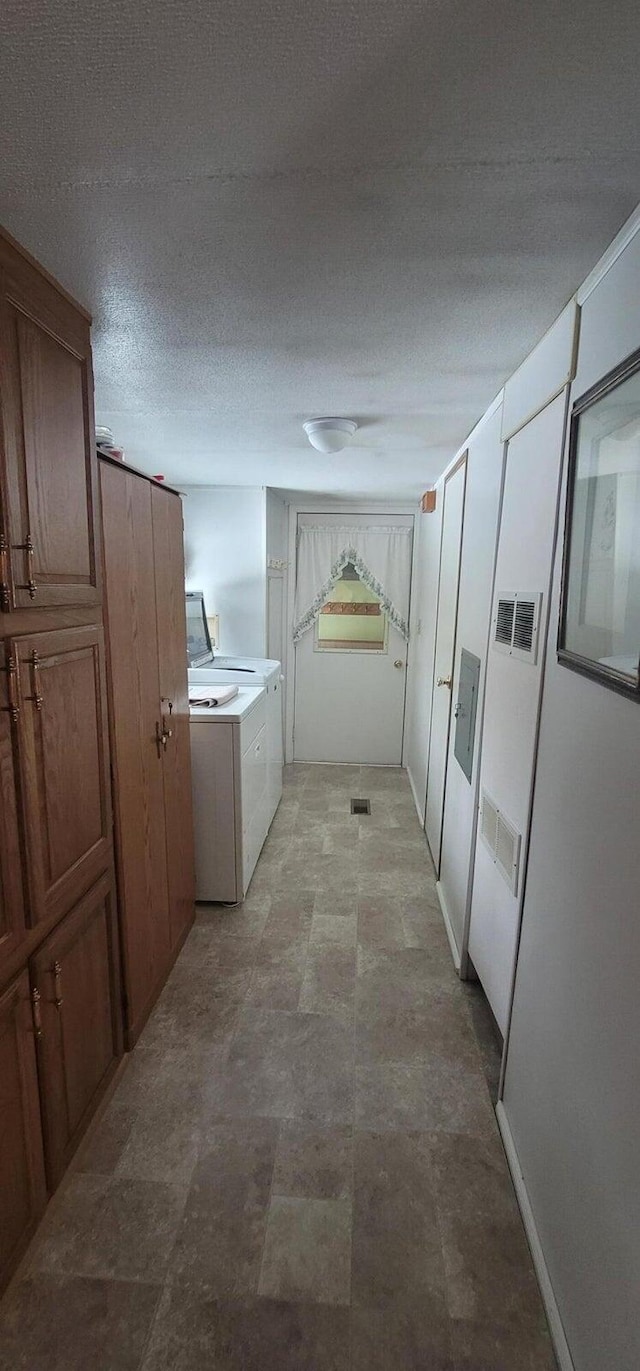 laundry area featuring washer and dryer and a textured ceiling