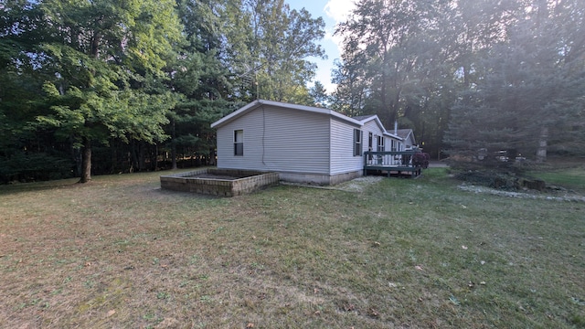 view of property exterior featuring a lawn and a wooden deck