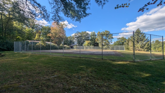 view of tennis court featuring a lawn