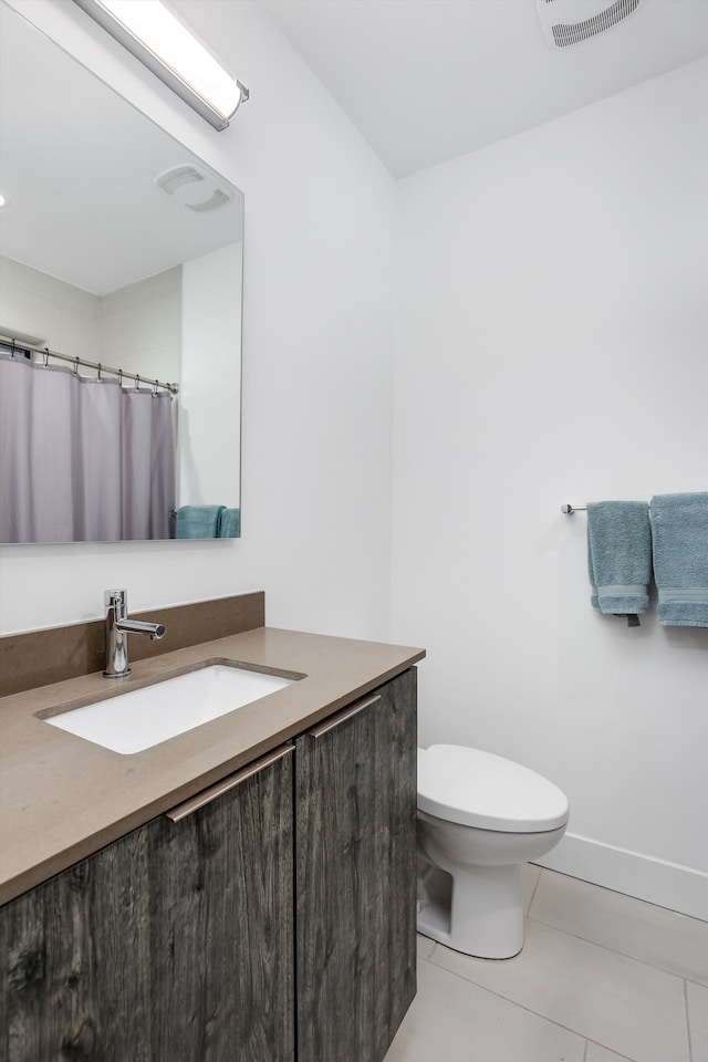 bathroom featuring tile patterned flooring, vanity, and toilet