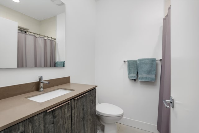 bathroom with tile patterned flooring, vanity, and toilet