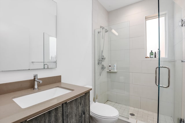 bathroom featuring vanity, toilet, and a shower with door