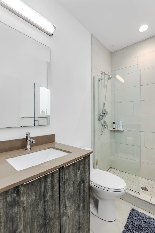 bathroom featuring tile patterned floors, vanity, walk in shower, and toilet