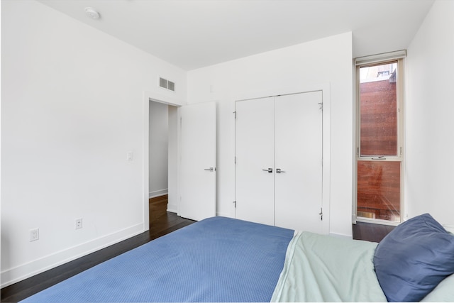 bedroom featuring a closet and dark hardwood / wood-style flooring