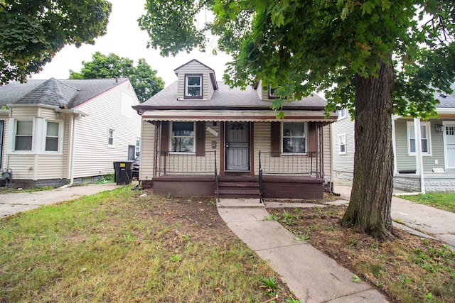 bungalow-style home featuring a porch and a front yard