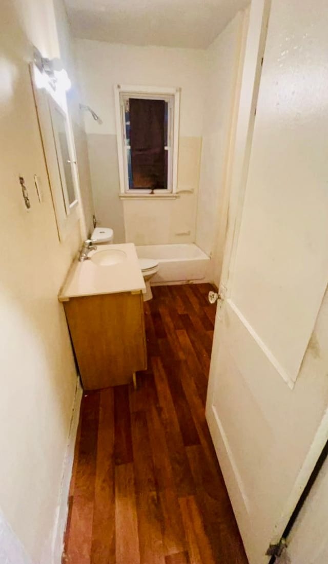 full bathroom with hardwood / wood-style floors, vanity, toilet, and shower / washtub combination