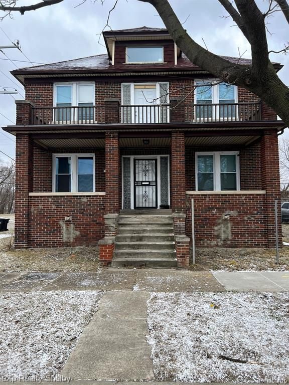 view of front of property with a balcony and brick siding