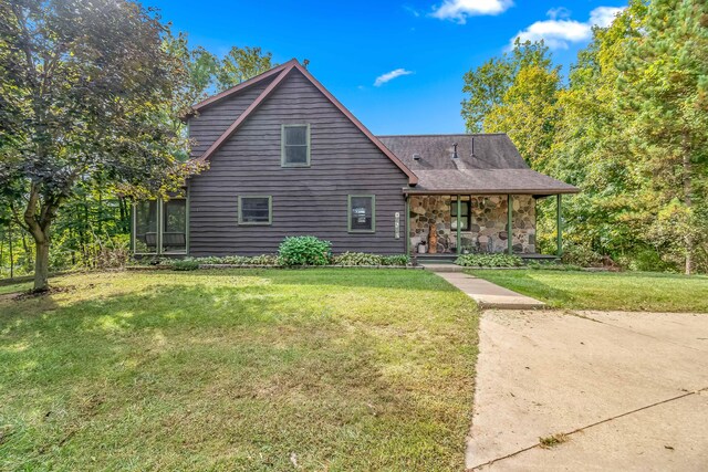 2488 Wilson St, Hillsdale, MI 49242 - view of front facade with a porch, a front yard, and stone siding