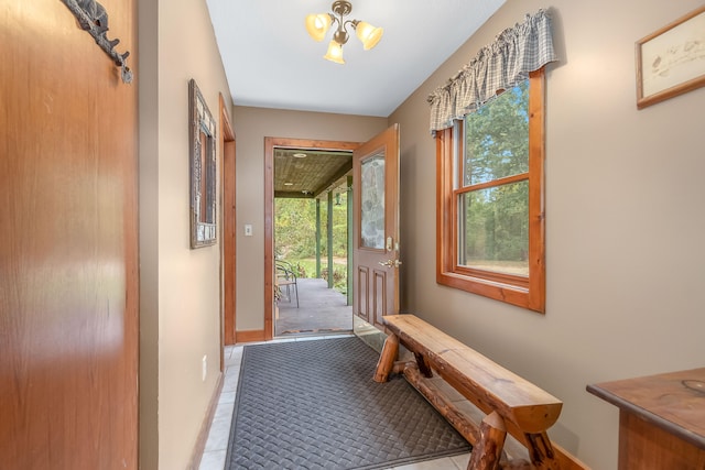 doorway with light tile patterned floors and a notable chandelier
