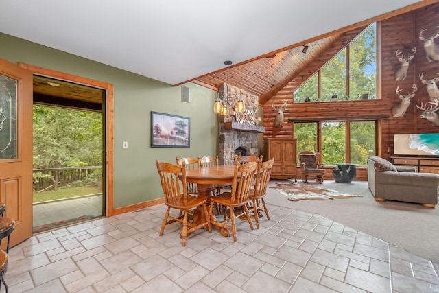 dining space featuring light carpet, wood ceiling, high vaulted ceiling, an inviting chandelier, and a stone fireplace