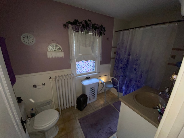 bathroom featuring radiator heating unit, vanity, toilet, and tile patterned floors