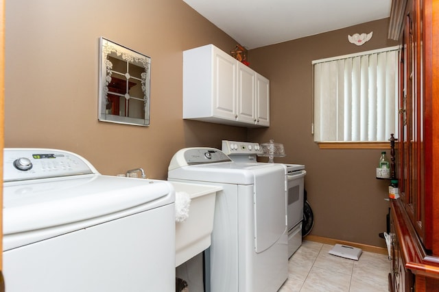 laundry area with washer and clothes dryer, light tile patterned flooring, and cabinets