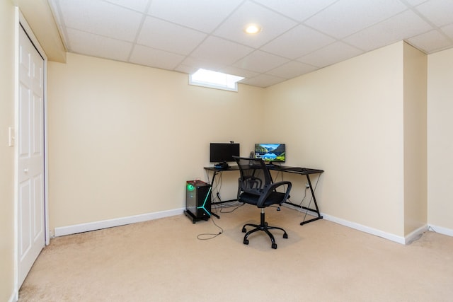 carpeted home office with a paneled ceiling