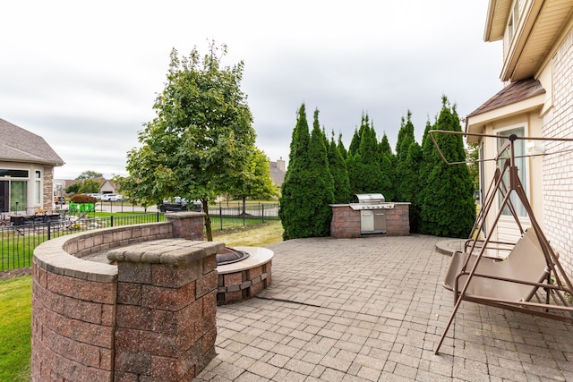 view of patio with an outdoor kitchen and an outdoor fire pit