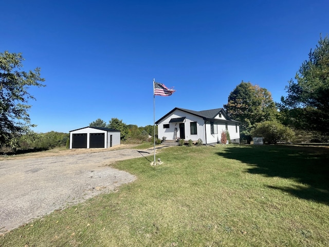 view of front of property featuring a garage, an outdoor structure, and a front yard