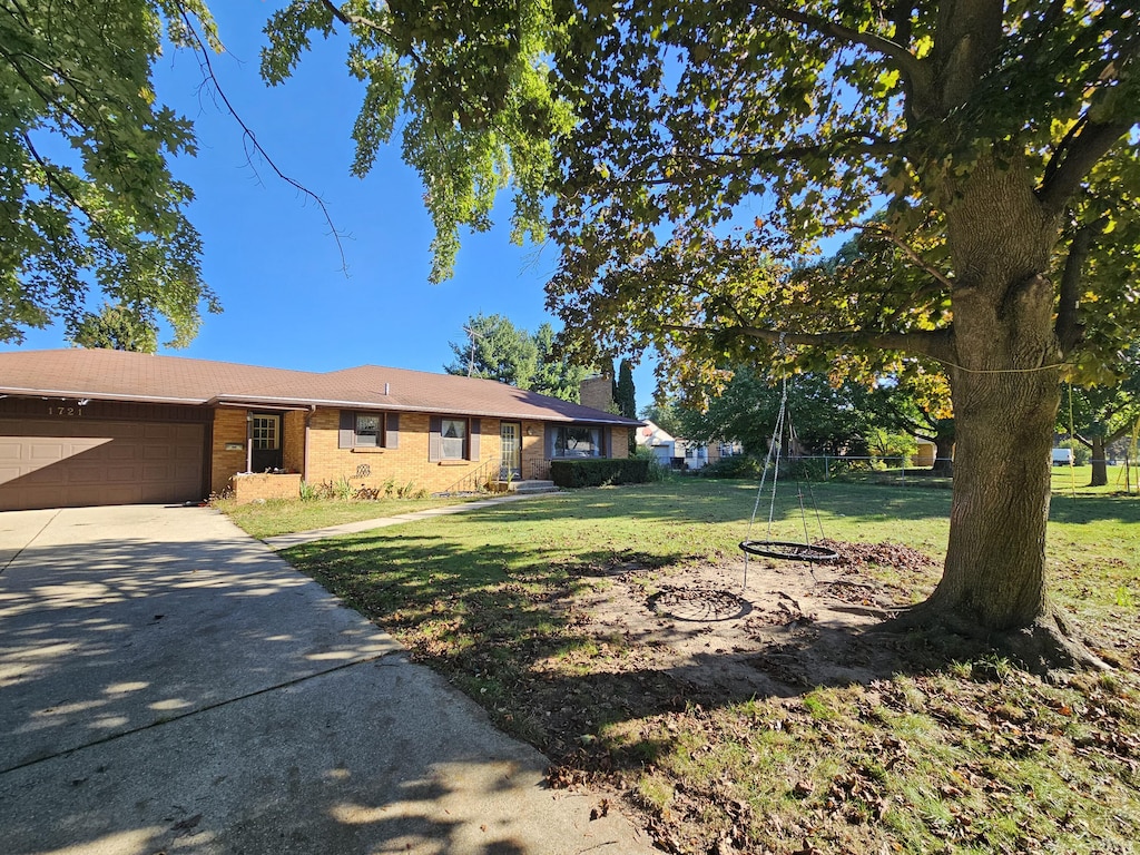 ranch-style home with a garage and a front yard