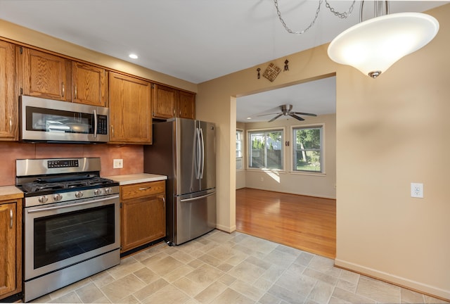 kitchen featuring appliances with stainless steel finishes, ceiling fan, and decorative backsplash