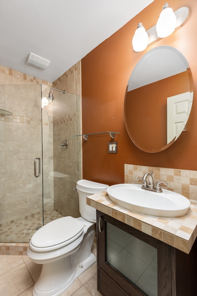 bathroom with sink, a shower with door, tile patterned flooring, and toilet