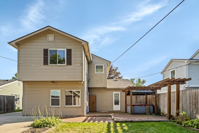 back of property featuring a patio area, a lawn, a hot tub, and a pergola