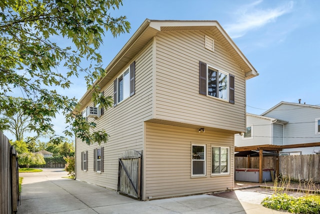 rear view of house with a hot tub and a patio