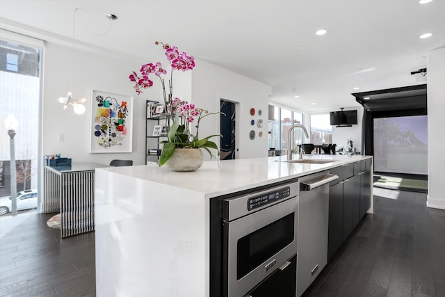 kitchen with dark hardwood / wood-style flooring, a spacious island, sink, and decorative light fixtures