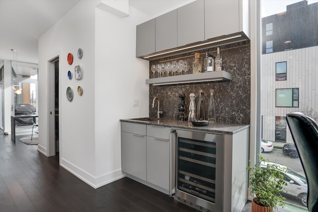 bar featuring sink, wine cooler, dark hardwood / wood-style flooring, gray cabinets, and decorative backsplash