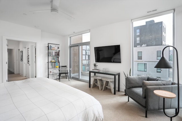 bedroom with light carpet, ceiling fan, and a wall of windows