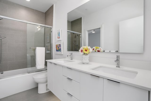 full bathroom with vanity, toilet, and bath / shower combo with glass door