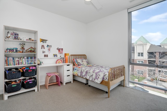 carpeted bedroom with ceiling fan and multiple windows