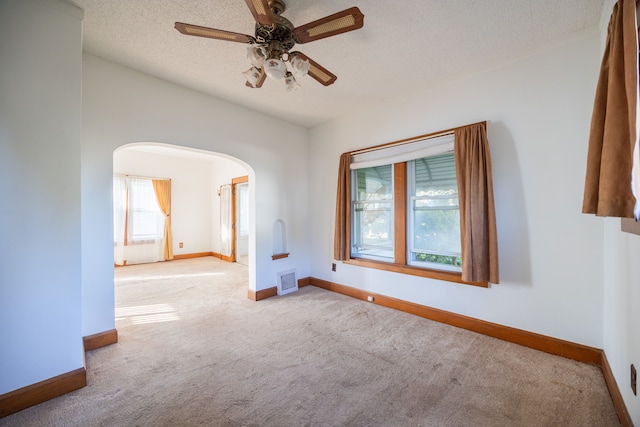 spare room with light carpet, a textured ceiling, and ceiling fan