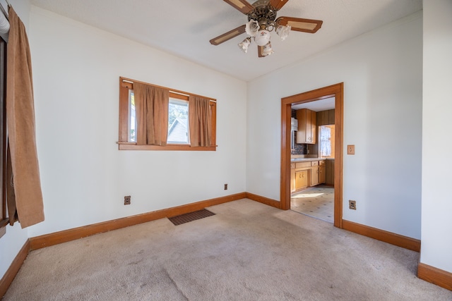 carpeted empty room featuring ceiling fan