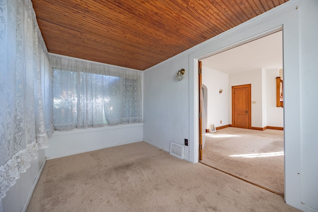 spare room featuring light carpet and wooden ceiling