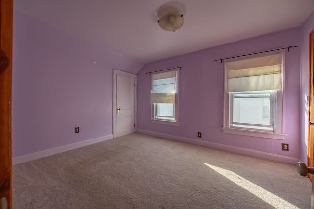 carpeted empty room with lofted ceiling