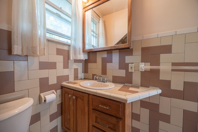 bathroom featuring backsplash, vanity, tile walls, and toilet