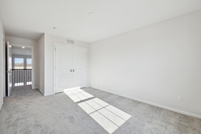 unfurnished bedroom with a closet, visible vents, baseboards, and carpet